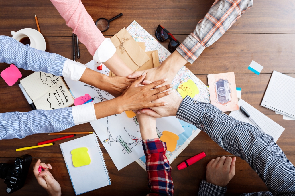 Picture of businessmen's hands on wooden table with documents and drafts